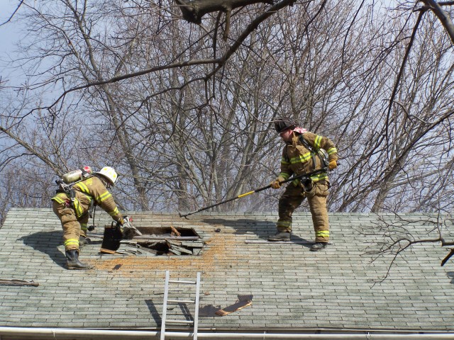 Fire Fighter Rich Klingler II and FF Fred Worster Venting the roof on Cemetery Road